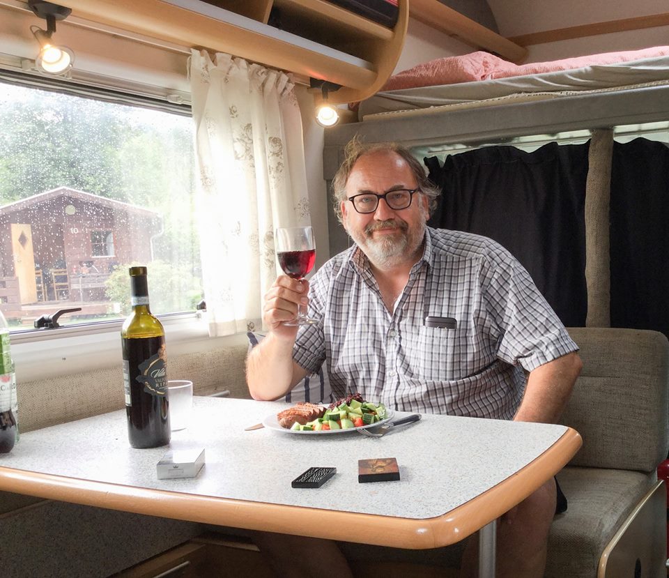 Foto av person ved bord inne i bobil.